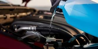 Antifreeze being poured into a car.