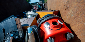 A vacuum cleaner, kettle and other waste electrical items in a container at a recycling centre.