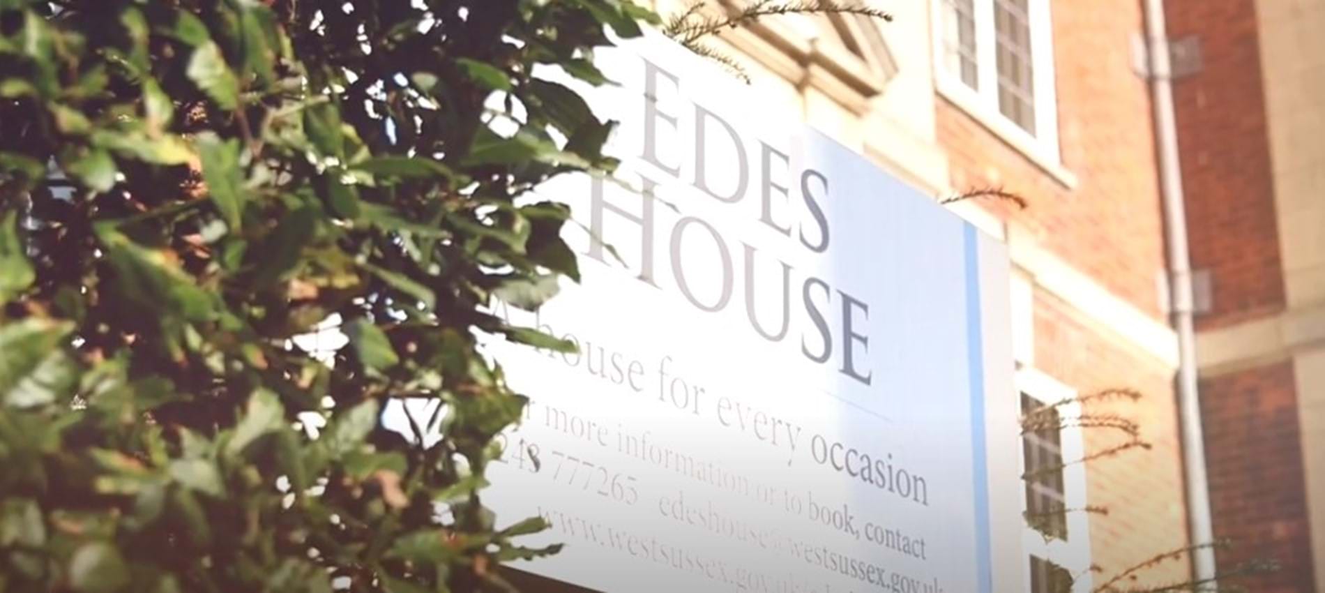 nojs Edes House sign and part of the building shaded by a tree
