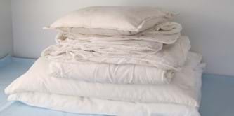 A pile of cushions, duvets and pillows.