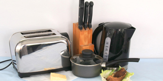 Items of kitchen waste - food, old saucepan, kettle, toaster.