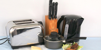 Items of kitchen waste - food, old saucepan, kettle, toaster.