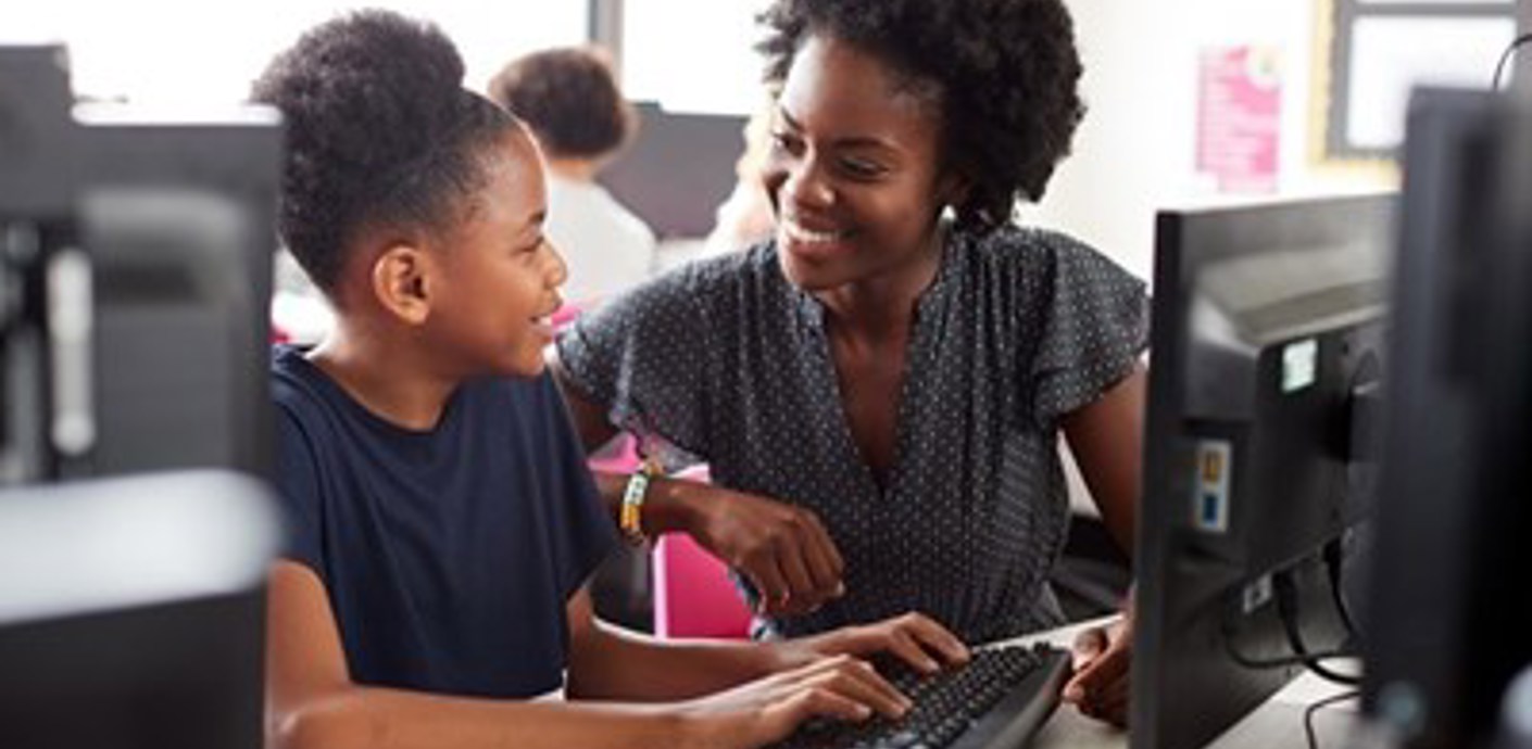 nojs Lady and girl smiling to each other whilst working at a computer