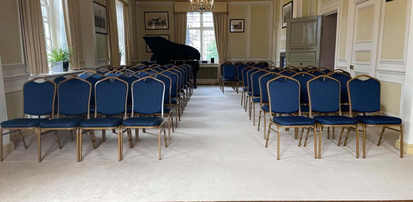 nojs View to back of Richmond Room with blue chairs and grand piano