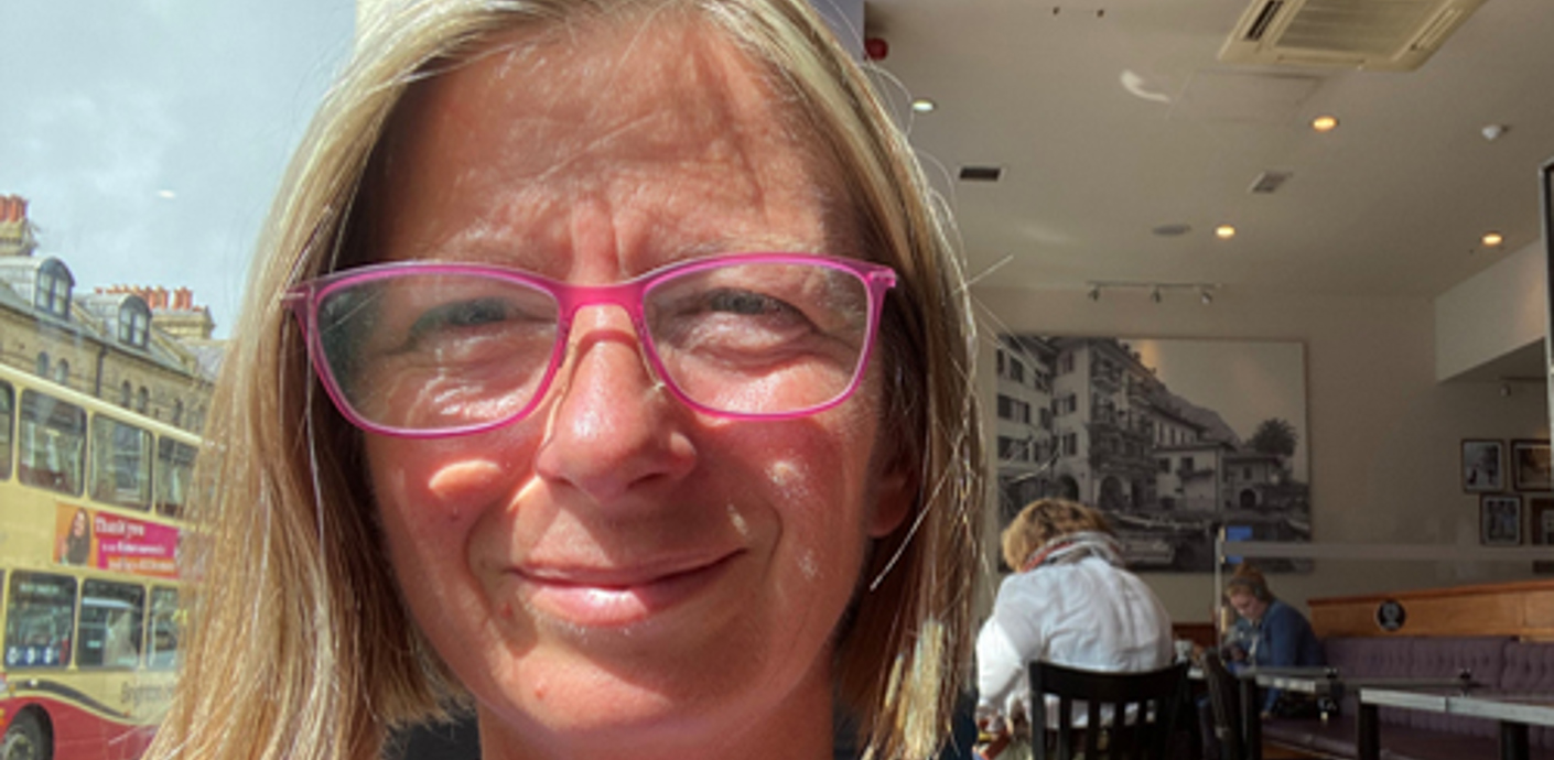 nojs Caroline standing at a sunny window