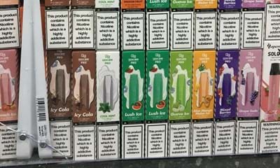 Numerous brightly coloured disposable vapes in cardboard packaging