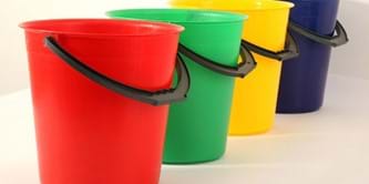 Red, green, yellow and blue plastic buckets in a line