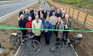 It’s officially open: Joy Dennis, the County Council’s Cabinet Member for Highways and Transport, cuts a ribbon stretched across the new, shared-use path, to mark the official opening of the improvement scheme