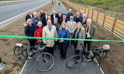 It’s officially open: Joy Dennis, the County Council’s Cabinet Member for Highways and Transport, cuts a ribbon stretched across the new, shared-use path, to mark the official opening of the improvement scheme