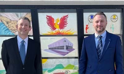Duncan Crow (West Sussex County Council Cabinet Member for Community Support, Fire and Rescue) and Gary Markwell (Adviser to the Cabinet Member for Community Support, Fire and Rescue) standing in front of the Worthing Library glass panel on Worthing Pier.