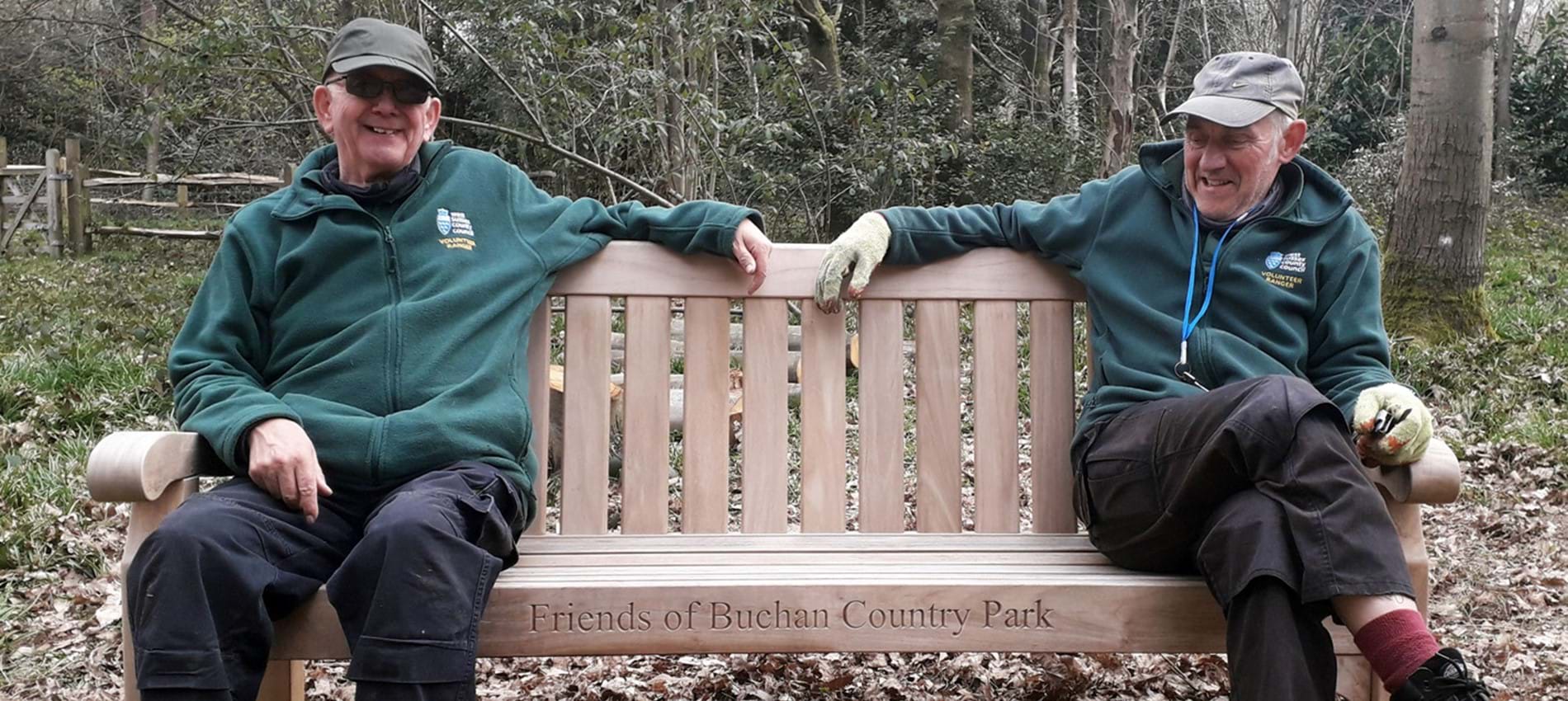 nojs two volunteers sat on a wooden bench