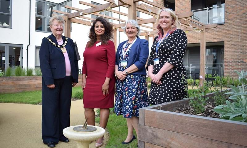 Four ladies stand around a sundial placed in the garden of the development to mark the official opening.