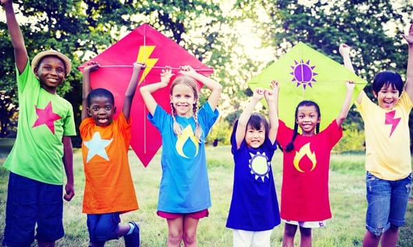Image of children in bright colours holding kites