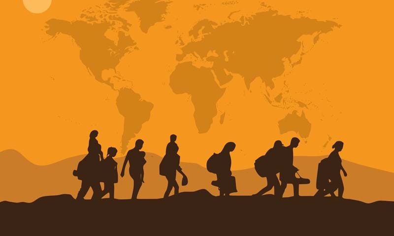 Silhouette of people walking across an orange landscape with the world map behind
