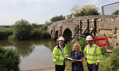 Pictured on the slipway beside the ancient bridge are (from left) Michael Taylor, the County Council’s Engineering Project Manager, business owner Helen Johnson with the capsule, and Richard Finn, Director of Principal Contractor Landbuild
