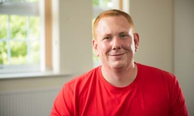 Portrait picture of foster carer James Witchell-Towers in a red t-shirt