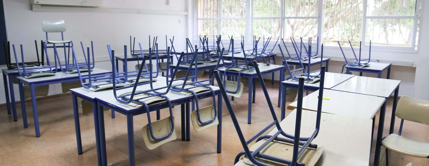 Empty school classroom with chairs on table