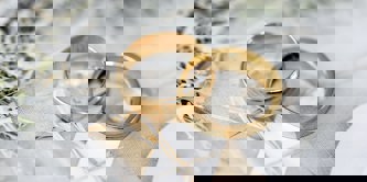 Two gold rings on a decorative background.