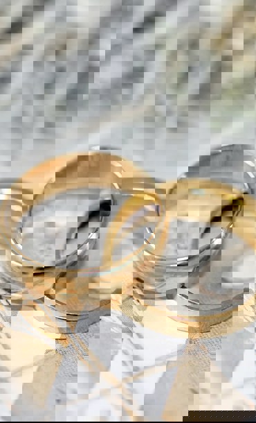 Two gold rings on a decorative background.