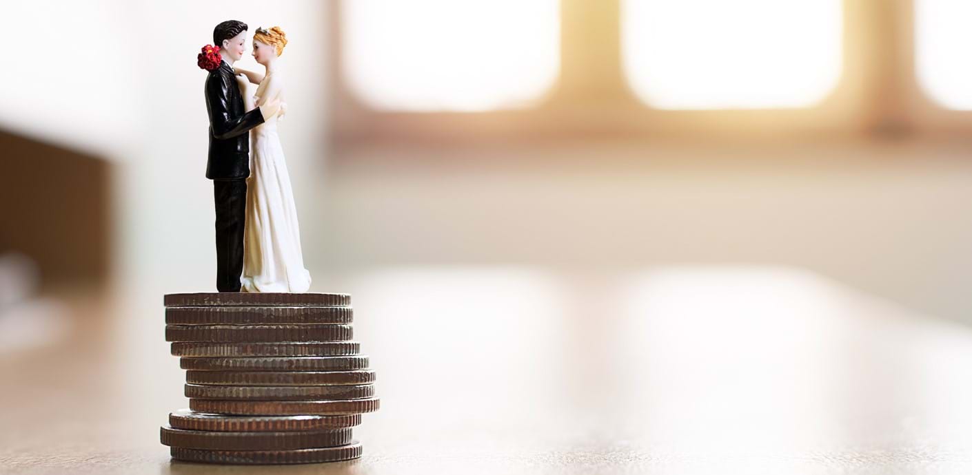 nojs Figurine bride and groom standing on top of a pile of coins.