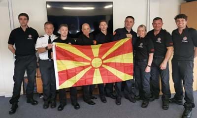 North Macedonian firefighters and West Sussex firefighters holding the North Macedonian flag