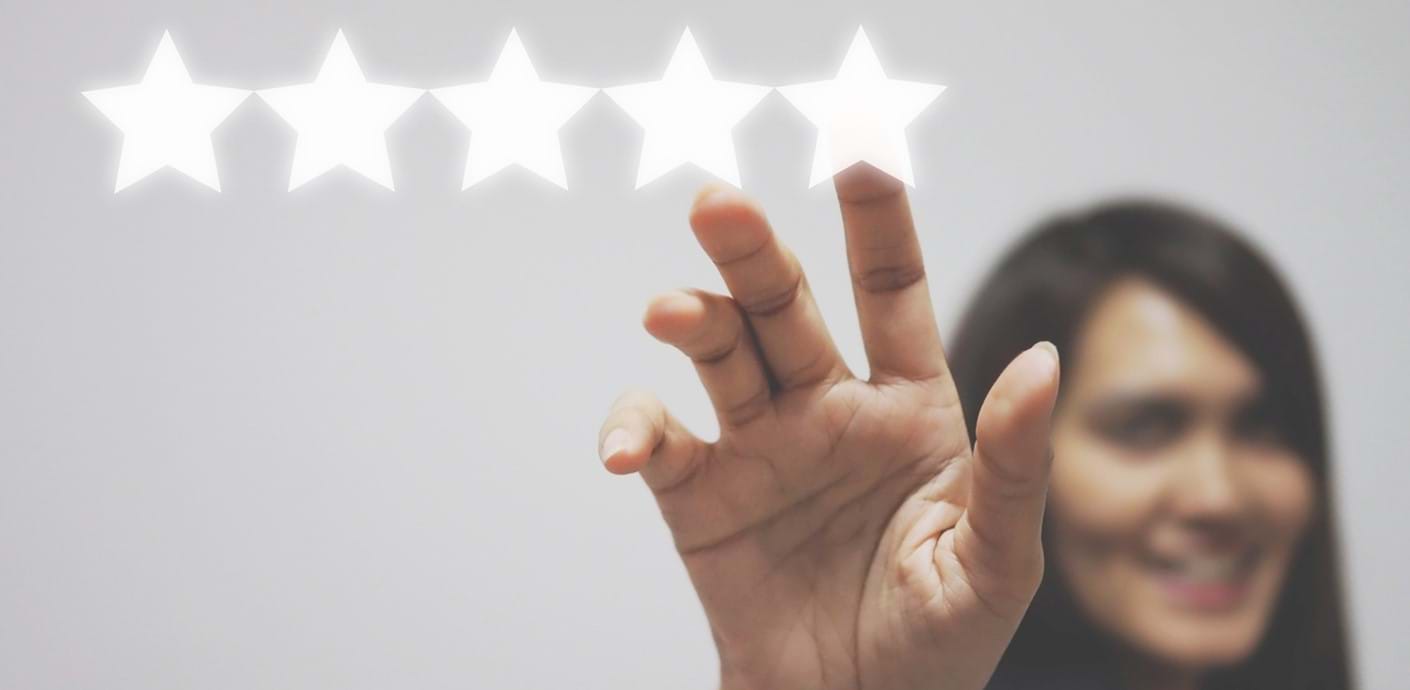 nojs A woman holding up her hand and touching the fifth of five stars in a row.
