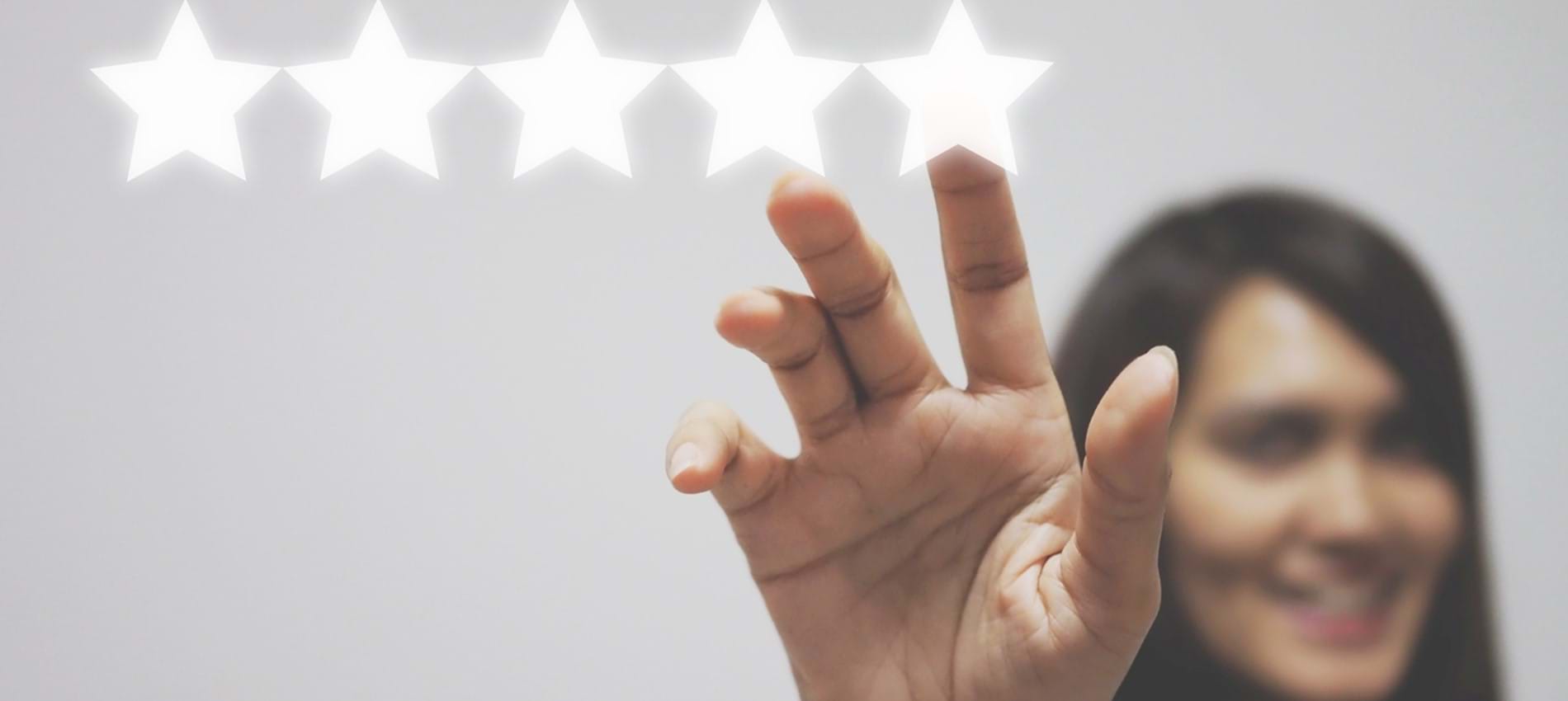 nojs A woman holding up her hand and touching the fifth of five stars in a row.