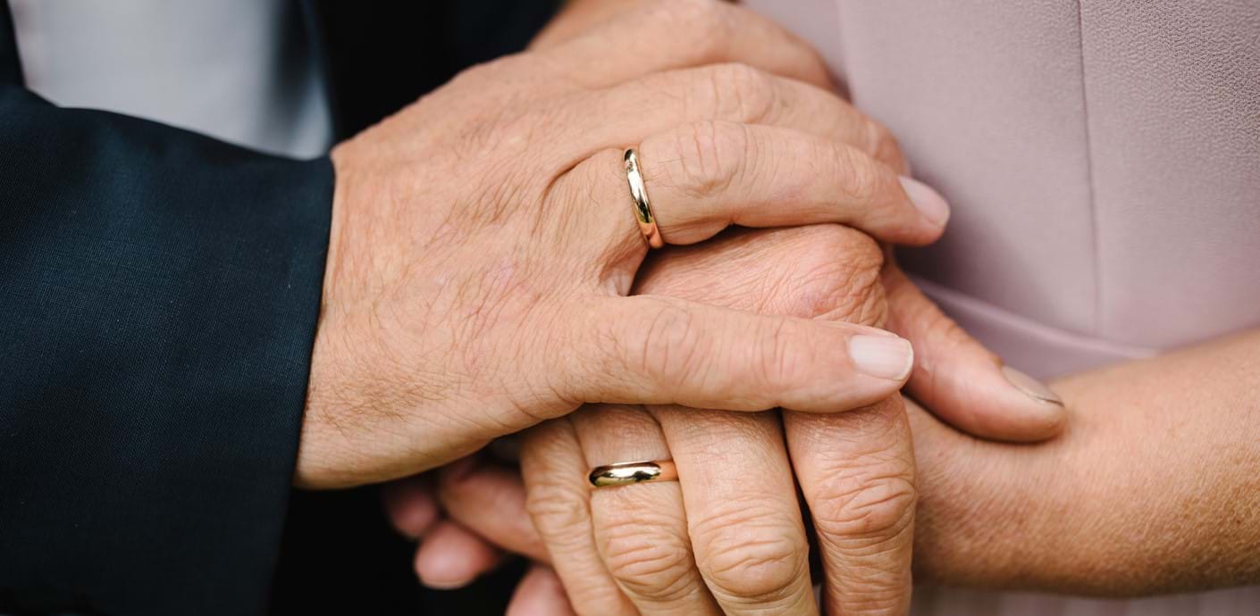nojs Two people holding hands with rings on their fingers