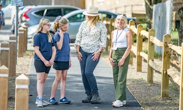 Perusing the footway improvements and new crossing points near Barns Green Primary School: from left, two of the school's pupils with County Council Cabinet Member for Highways and Transport Joy Dennis and Headteacher Tracey Newbold