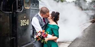 Bride and groom next to a train