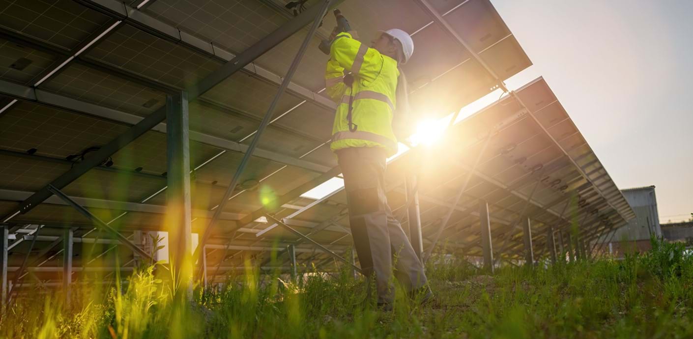 nojs Man installing solar panels in a field