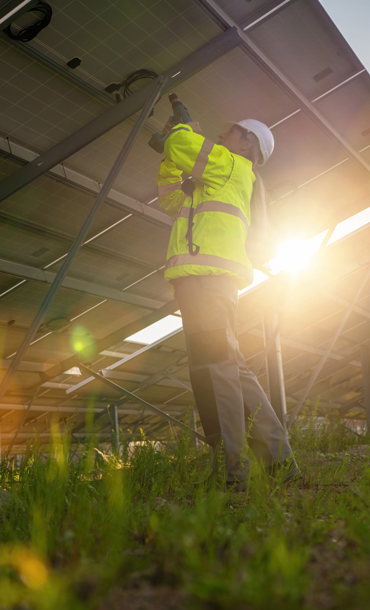 Man installing solar panels in a field