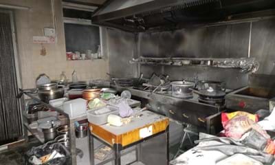 Photo shows a kitchen covered in soot and scorch marks on the walls.