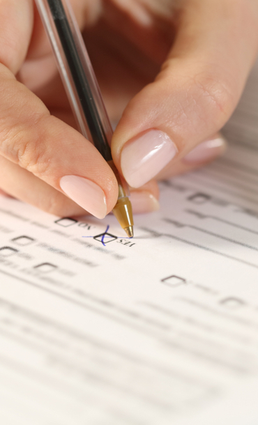 Hand with pen completing a form.