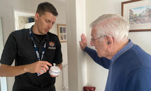A Community Fire Safety Officer showing a resident a smoke alarm