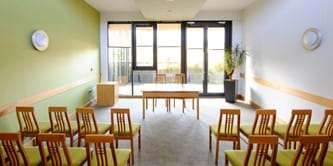 Chairs laid out in a bright, modern room facing glass windows and doors