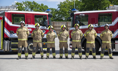 New on-call firefighters standing in front of fire engines
