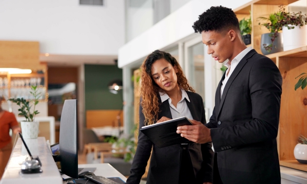 A man and woman looking at a clipboard