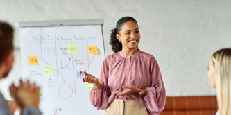 Business colleagues engaged in a positive discussion in a contemporary office environment with young female presenter. 