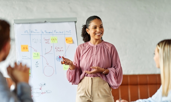 Business colleagues engaged in a positive discussion in a contemporary office environment with young female presenter.