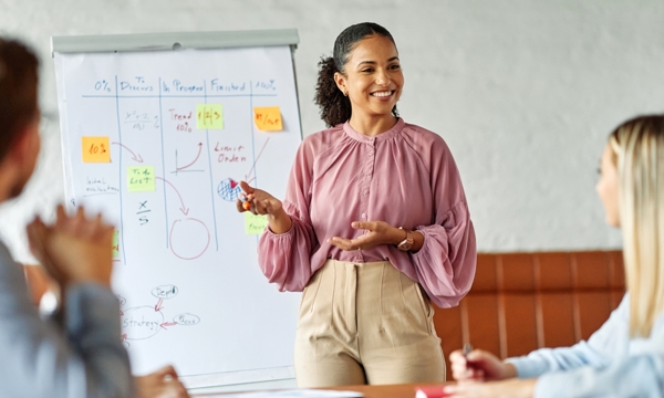 Business colleagues engaged in a positive discussion in a contemporary office environment with young female presenter.