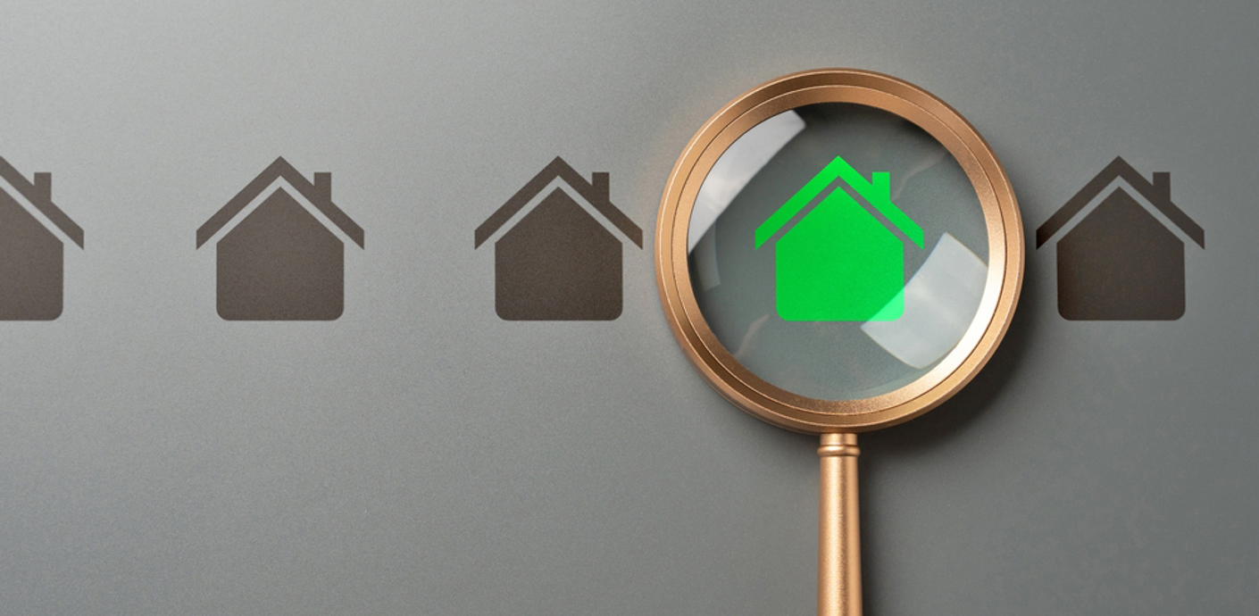 nojs Little house symbols in black colour with one in green underneath a magnifying glass.