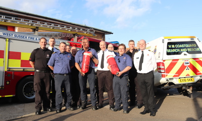 West Sussex Fire & Rescue Service and HM Coastguard staff standing in front of a fire engine