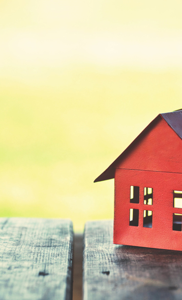 Little red house on a wooden picnic bench.