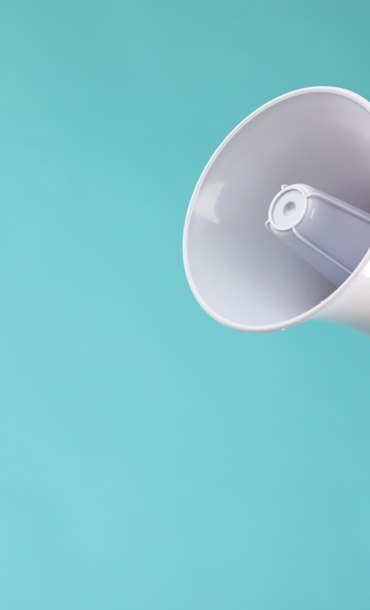 Person's hand holding up a megaphone.
