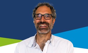 A head and shoulders image of Councillor Sam Raby who is wearing glasses and a white shirt, and smiling into the camera. 
