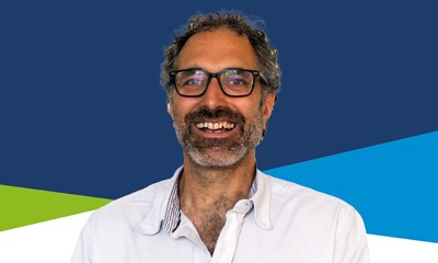 A head and shoulders image of Councillor Sam Raby who is wearing glasses and a white shirt, and smiling into the camera. 