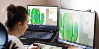 A girl looking at multiple computer screens