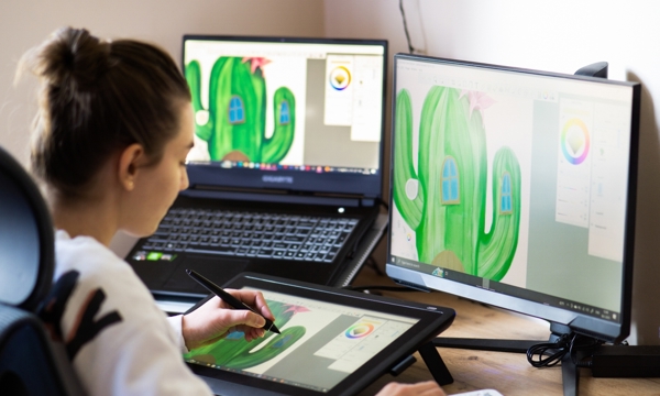 A girl looking at multiple computer screens