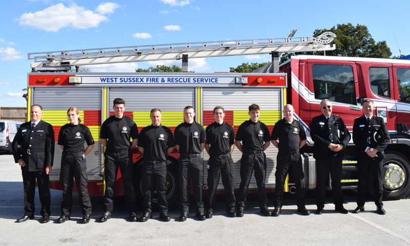 New on-call firefighters lined up in front of a fire engine